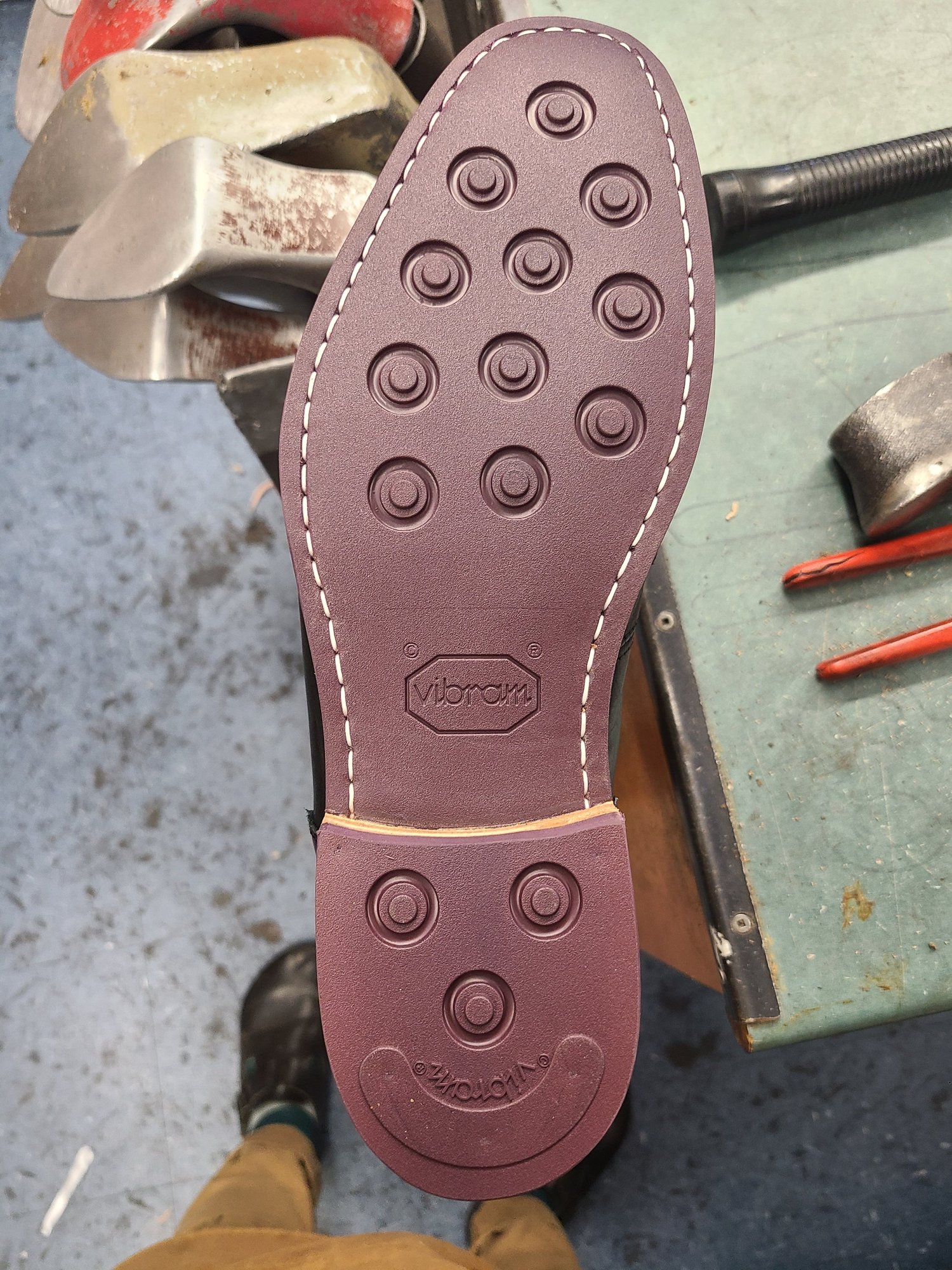 The sole of a new Vibram shoe sole featuring a pattern of circular treads and the Vibram logo.