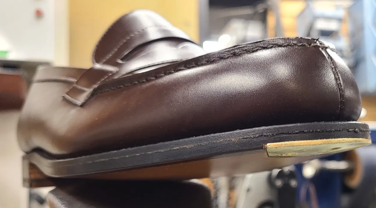 Metal toe plate fitted flush into a leather dress-shoe sole